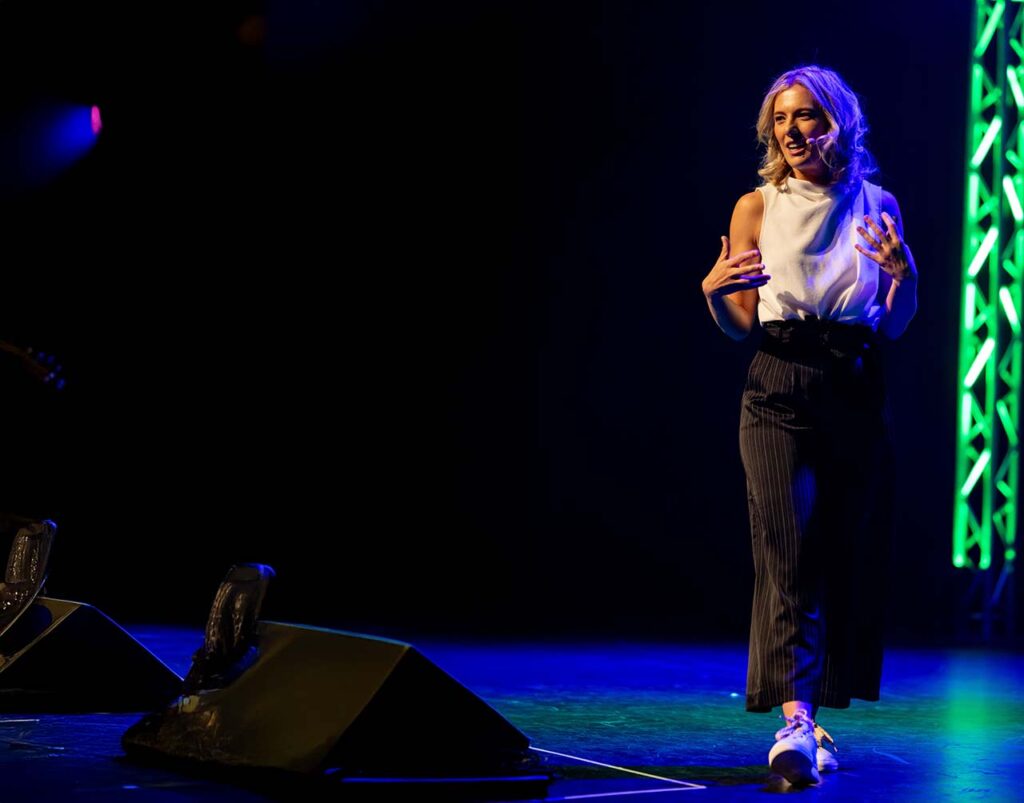 Juliette addressing an audience on a conference stage